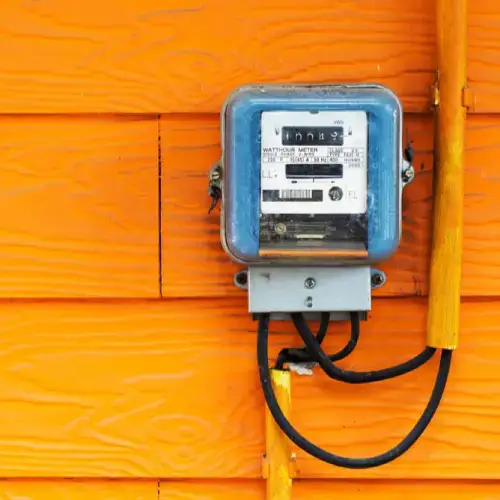 An electricity meter on an orange wall