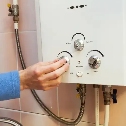 Hand turning dial on gas hot water system